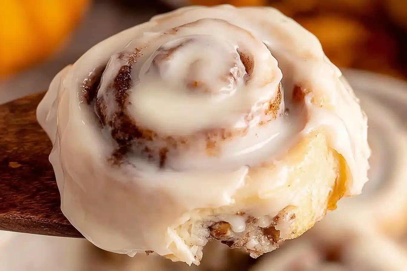 Freshly baked pumpkin cinnamon rolls topped with creamy icing