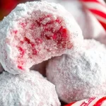 Delicious peppermint snowball cookies dusted with powdered sugar on a festive background.
