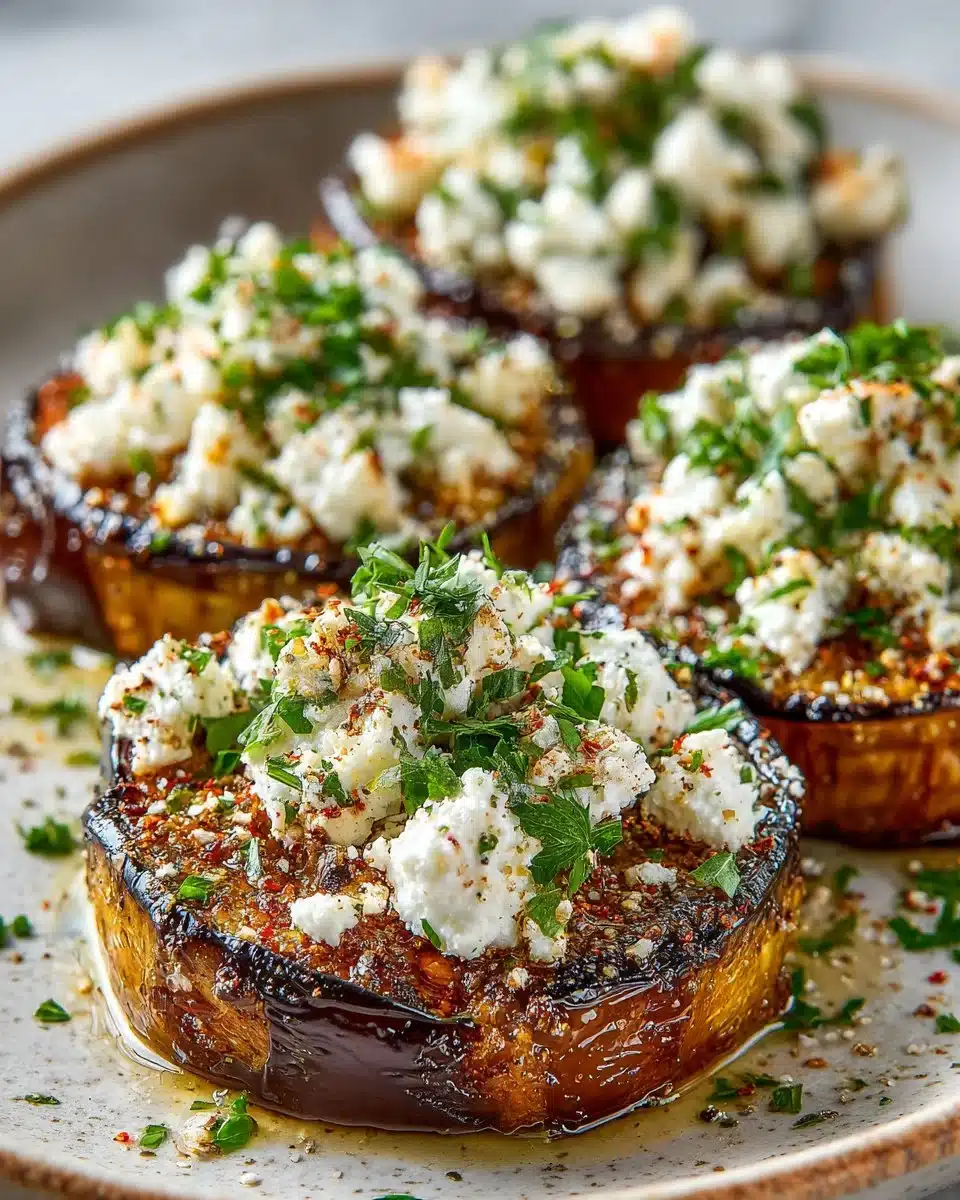 Herb crusted roasted eggplant topped with feta cheese on a plate.